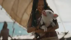 Catherine Laga'aia segura um porco em uma cena do remake em live-action de Moana, lançado em 2026