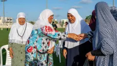 عدد من النساء المسلمات يتبادلنّ التهاني خلال احتفالات عيد الأضحى.