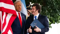 Donald Trump e Javier Milei entre as bandeiras dos Estados Unidos e da Argentina durante um encontro em Washington.