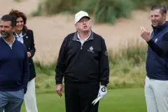 O presidente americano, Donald Trump, na cerimônia de inauguração de um novo campo de golfe em Balmedie, perto de Aberdeen, Escócia, em 29 de julho de 2025. Ele veste um conjunto de moletom esportivo e boné escrito "USA" e segura uma tesoura usada para cortar a faixa inaugural
