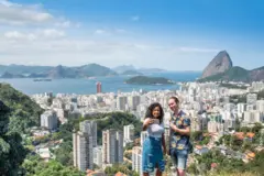 Uma moradora e um turista tiram foto no Rio, com o Pão de Açúcar ao fundo 