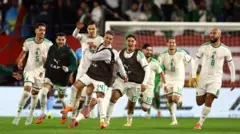 عادل بولبينا، لاعب المنتخب الجزائري، يحتفل بتسجيل الهدف الأول مع زملائه في الوقت الإضافي.