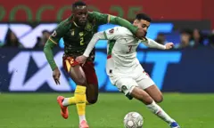 Le défenseur camerounais n° 2, Junior Tchamadeu, et le défenseur marocain n° 3, Noussair Mazraoui, se disputent le ballon lors du quart de finale de la Coupe d'Afrique des Nations (CAN) opposant le Cameroun au Maroc au stade Prince Moulay Abdallah de Rabat, le 9 janvier 2026. 