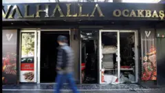 Čovek gleda u prolazu zapaljenu radnju turskog državljanina u Podgorici