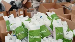 Ahbap yardım derneğinin logosunu taşıyan poşetler ve deprem yardımlarının taşındığı koliler görülüyor.