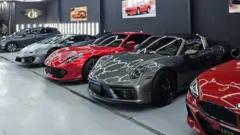 Carros de luxo lado a lado dentro de concessionária