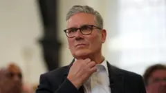 Primeiro-ministro britânico com a mão na gola da camisa
