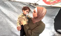 سيدة تحمل طفلاً.