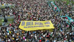 Manifestante a favor da tarifa zero em Belo Horizonte segurando uma faixa amarela e roxa onde se lê "BH quer busão 0800 bh.busao0800.com"