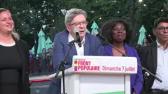 支持者集会で演説するメランション氏