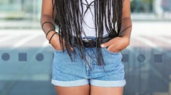 한 여성이 짧은 청바지 주머니에 손을 넣고 있다. 