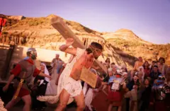 Encenação da Paixão de Cristo, em que o homem que interpreta Jesus carrega a viga de madeira