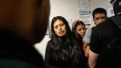 Mónica ao lado do marido, que está sendo detido por agentes