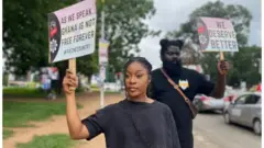 Protesters hold placard