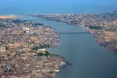 Foto aérea mostra Cotonou, com rio, pontes e mar ao fundo
