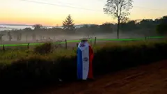 Una persona envuelta en la bandera paraguaya observa el amanecer cerca de Encarnación, Paraguay.