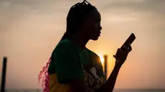 ስልክ የያዘች ወጣት 