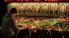 Un hombre rinde homenaje a los bomberos fallecidos por el desastre.