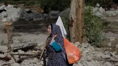 امرأة فلسطينية تسير وهي ترفع الراية البيضاء في قطاع غزة