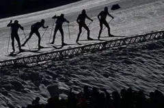 Varios esquiadores, y sus sombras, en una prueba de esquí de fondo en Milán-Cortina 2026