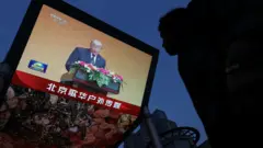 北京一處大型電視屏幕下民眾駐足收看正在播出的中國中央電視台《新聞聯播》，當中正在報導特朗普發言（14/5/2026）