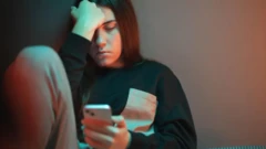 نوجوانی اندوهگین موبایلی را به دست گرفته