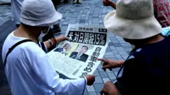 東京街頭兩位老婦閱讀《讀賣新聞》報導美日達成貿易協定的號外（23/7/2025）