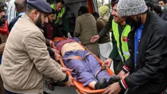 Люди несут раненого мужчину в больницу после взрыва в мечети в Исламабаде 