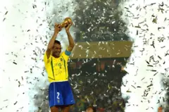 Café sostiene la copa del mundo en celebración