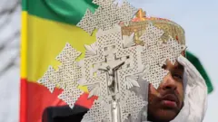 A deacon peers from behind a processional cross during a demonstration at the White House on February 05, 2023 in Washington, DC.