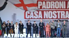 Sağ siyasetçiler "Kendi evimizde, ev sahibi biziz!" yazılı posterin önünde mitinge gelenleri alkışlıyor