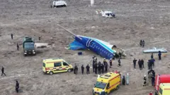 People surround a plane involved in an accident