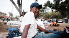 Jesús Andueza con una camiseta blanca y un pantalón azul en un campamento improvisado en La Guaira.
