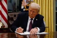 Trupm assinando um papel 