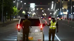 කාර් රථයක් පරික්ෂා කෙඅන පොලිස් නිලධාරීන් දෙදෙනෙක් 