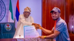 President Tinubu handing out cheque to a beneficiary of student loan