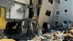 Karolyn Sánchez saliendo del edificio inclinado a y bajo los escombros con la ayuda de su expareja.