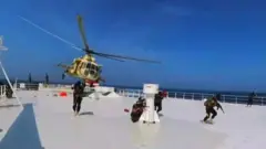 A Houthi helicopter and landing team on a ship