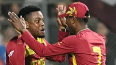 ज़िम्बाब्वे का एक विकेट गिरने के बाद शिमरोन हेटमायर और अकील होसेन जश्न मनाते हुए 