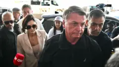 Jair Bolsonaro acompanha sua esposa, michelle Bolsonaro na entrada do aeroporto de Brasília em 18 de janeiro de 2025.
