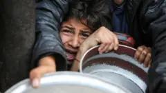 فلسطينيون يتجمعون لتلقي الطعام المطهو في مطبخ خيري في خان يونس جنوب قطاع غزة