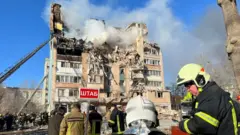 Ratownicy pracują na miejscu, gdzie rosyjski atak rakietowy uderzył w budynek mieszkalny w Tarnopolu