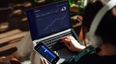 مردی در حال کار کردن با لپ تاپ و گوشی همراه