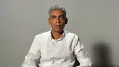 El ingeniero estructural Andrik Soto, con camisa blanca y gesto serio, mira de frete a la cámara.