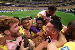 Jogadores do Brasil abraçando em campo comemorando a classificação do Brasil para as oitavas de final