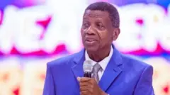 Pasitọ Enoch Adeboye , o wọ aṣọ alawọ aro to ni itẹnu funfun. Baba naa n sọrọ sinu ẹrọ gbohungbohun
