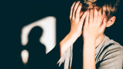 Мальчик закрывает руками лицо