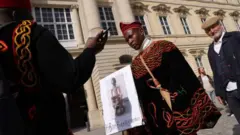 Umugabo ufite icyapa kiriho ishusho