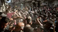 غزيون يصطفون أمام شاحنات المساعدة