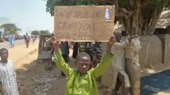 "በአሳሳቢ ሁኔታ ላይ ነን" የሚል ጽሁፍ የያዘ ታዳጊ